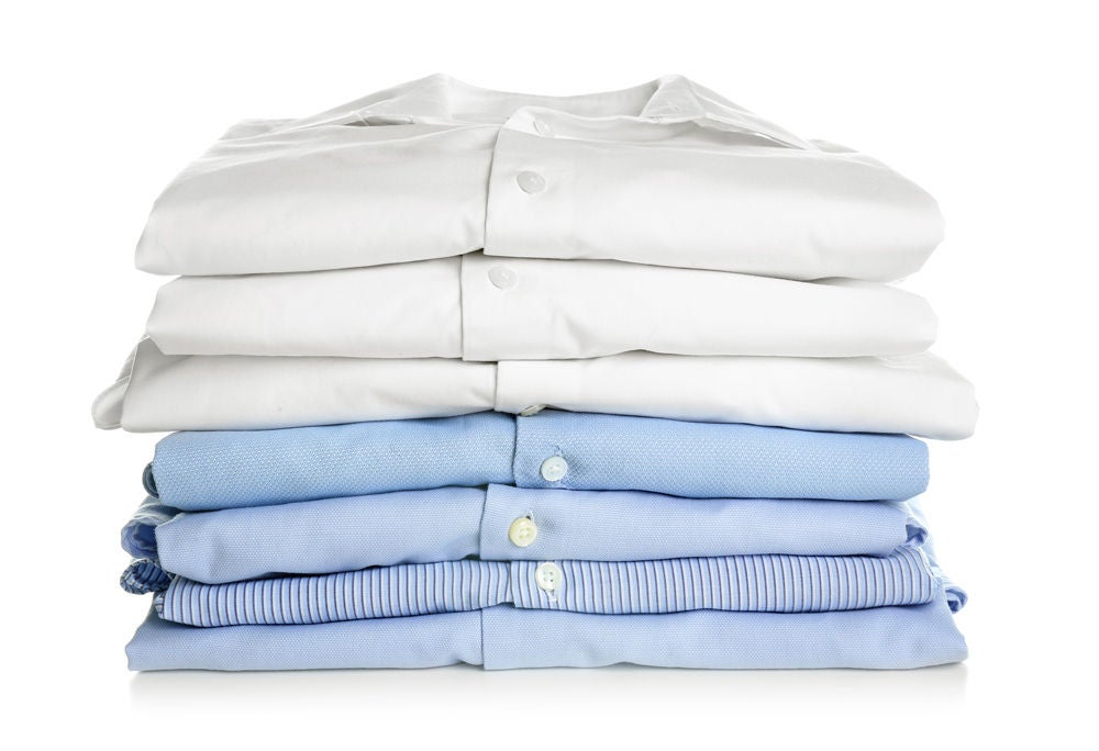 Stack of clean folded shirts on white background. Laundry day
