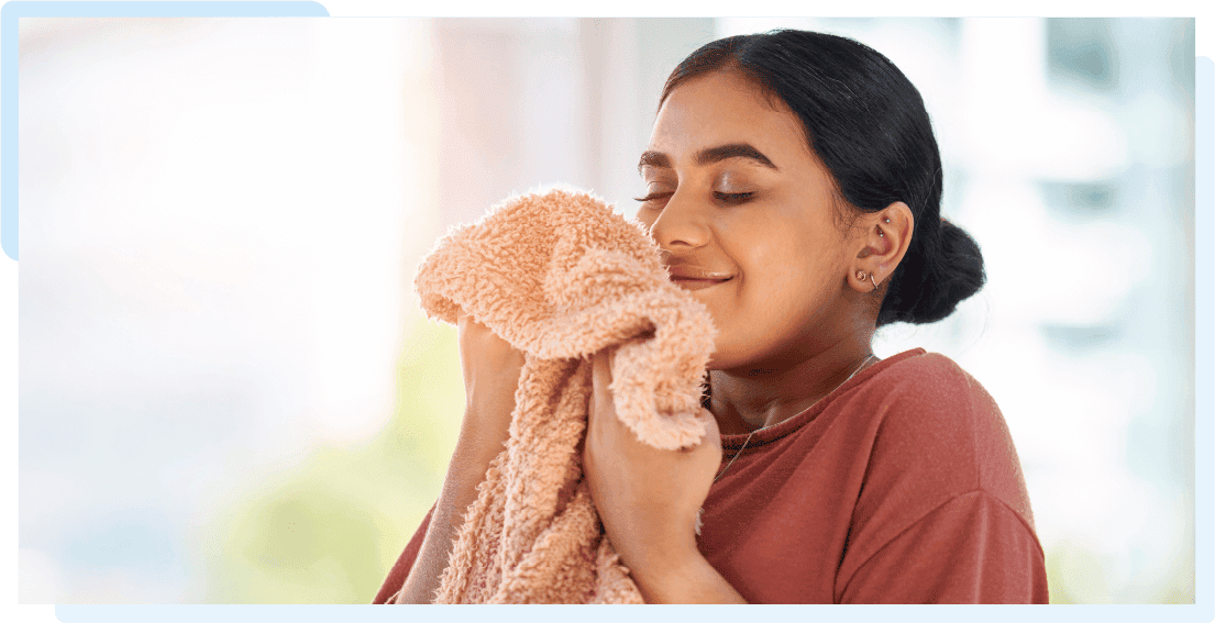 A woman smelling the delightful fragrance of her freshly washed laundry